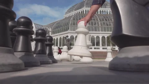 Womans hand places large park chess pawn piece on board weekend Video stock 336077585