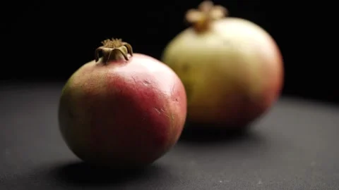 Woman's hand placing red grenade on table. Black background, close-up. Stock Footage 272184663