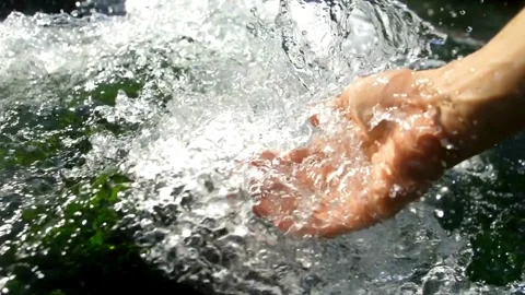 A woman's hand is playing and scooping water in a clean river. environment. Stock Footage 270318914