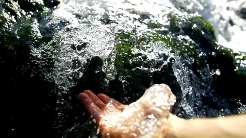 Woman's hand is playing and scooping water in a clean river. Hand scooping Video stock 270319034