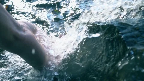 Woman's hand is playing and scooping water in a clean river. Hand scooping Stock Footage 270466737