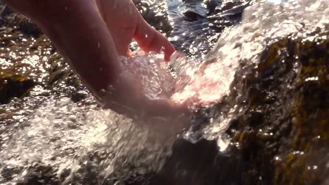 A woman's hand is playing and scooping water in a clean river. environment. Stock Footage 270466784