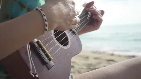 Woman's Hand Plays Ukulele. Close Deck View. Slow Motion Stockbeeldmateriaal 67215111