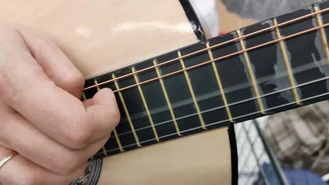 A woman's hand plucks the strings on a musical instrument. Stock Footage 220606200