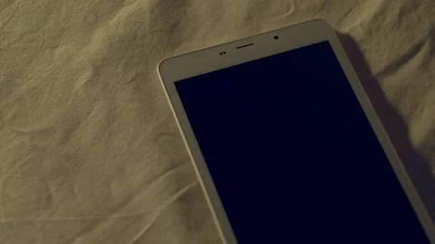 Woman's hand plugging white charging cable into digital tablet that discharged. Video stock 126495905