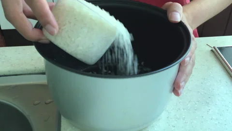 Woman's hand pouring rice 스톡 동영상 155378909