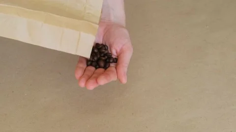 Woman's hand pours coffee beans from a paper bag into her palm. Stock Footage 201229576