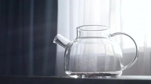A woman's hand pours dry tea into teapot Stock Footage