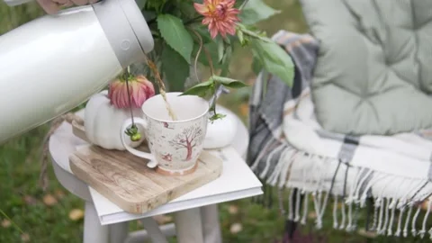 A woman's hand pours tea into a cup from a thermos in a beautiful autumn park. Stock Footage 161569841