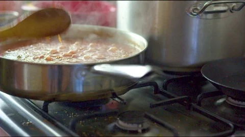 Woman's hand preparing food on kitchen stove Vidéo 76133891