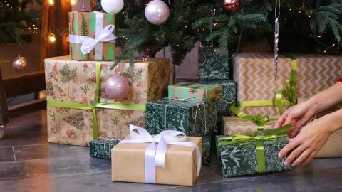 Woman's hand preparing gifts under the christmas tree Stock Footage 164973490