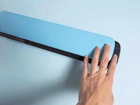 A woman's hand presses the button of a blue vacuum packer. the concept of pre Stock Photos