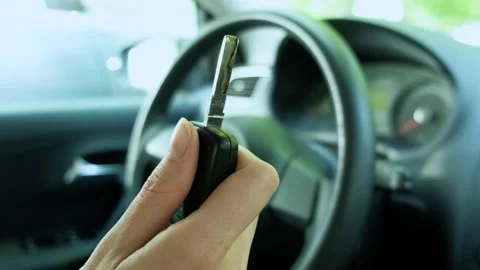 A woman's hand presses the button of a car keychain and the key pops out Stock Footage 240858758