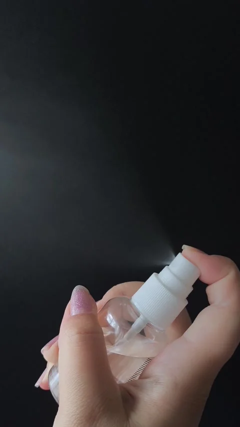 A womans hand presses the button of a transparent plastic spray bottle and Vídeo Stock 314974957