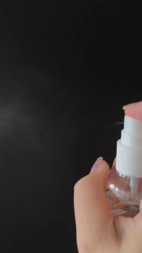 A womans hand presses the button of a transparent plastic spray bottle and Stock Footage 314975084