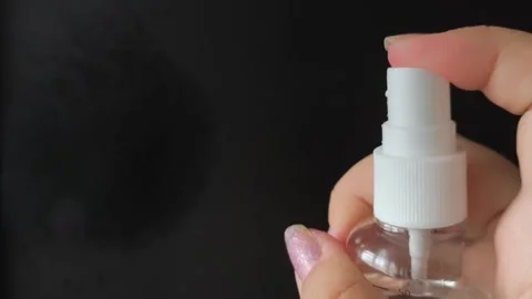 A womans hand presses the button of a transparent plastic spray bottle and Stock Footage 314975149