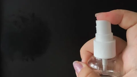 A womans hand presses the button of a transparent plastic spray bottle and Vídeo Stock 314975209