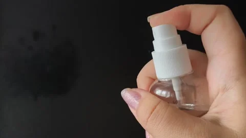 A womans hand presses the button of a transparent plastic spray bottle and Stock Footage 314975213