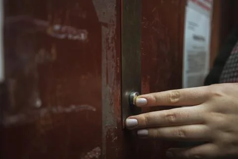 A woman's hand presses the elevator button Stock Photos