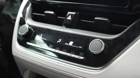 Woman's hand pressing the AC button on a car dashboard Stock Footage 345012487