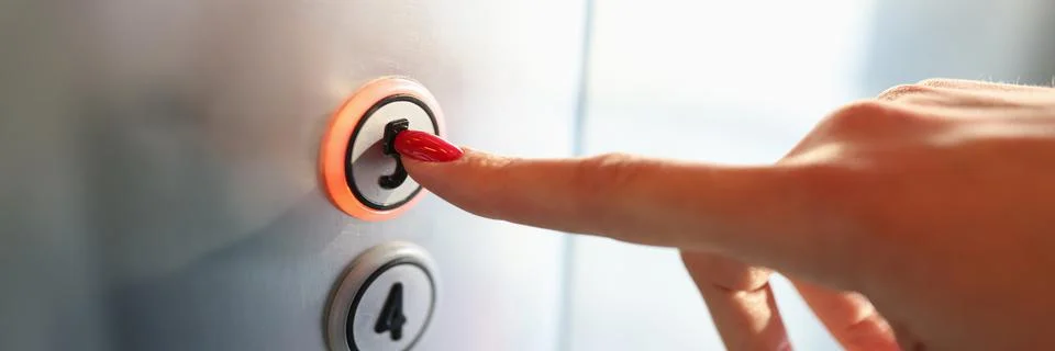 Womans hand pressing button of elevator to fifth floor close-up Stock Photos