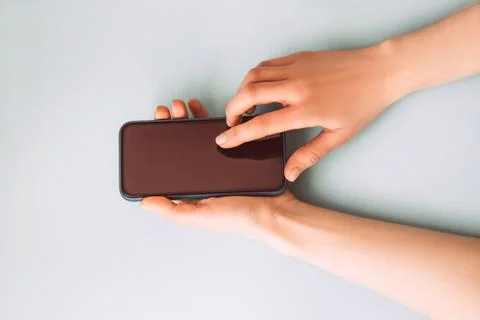 Woman's hand is pressing the button on smart phone screen Stock Photos