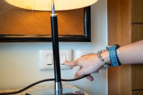 A woman's hand is pulling an electrical plug to turn off a switch. to save .. Stock Photos