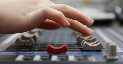 Woman's hand pulling up knobs of audio mixer in studio Video stock 82847527