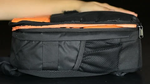 Womans hand pulling zipper of cameras bag to close Stock Footage 132610350