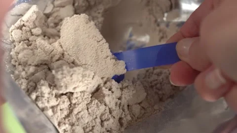 A woman's hand pulls protein powder from a packet, top view. Close-up. Video stock 309846025