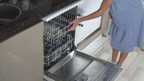A woman's hand pushes the top shelf and closes the dishwasher empty. Stock Footage 202171107