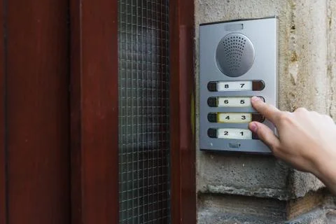 Woman's hand pushing intercom button at the front door. Annoying salesperson. Foto stock