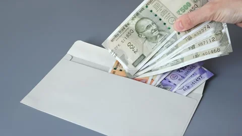 Woman's hand put several banknotes of Indian 500 rupees into the envelope Stock Footage 306082572