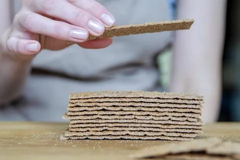 A woman's hand puts bread close-up. Sorting a small snack in the form of bread. Stock Photos
