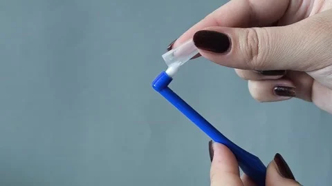 A womans hand puts on a cap on a single tuft toothbrush close-up. Oral hygiene Stock-Footage 329969543