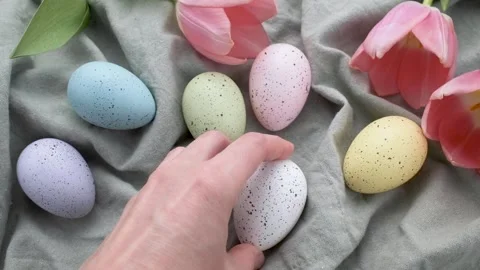 A woman's hand puts a colored Easter egg on the table. Stock Footage 234184768
