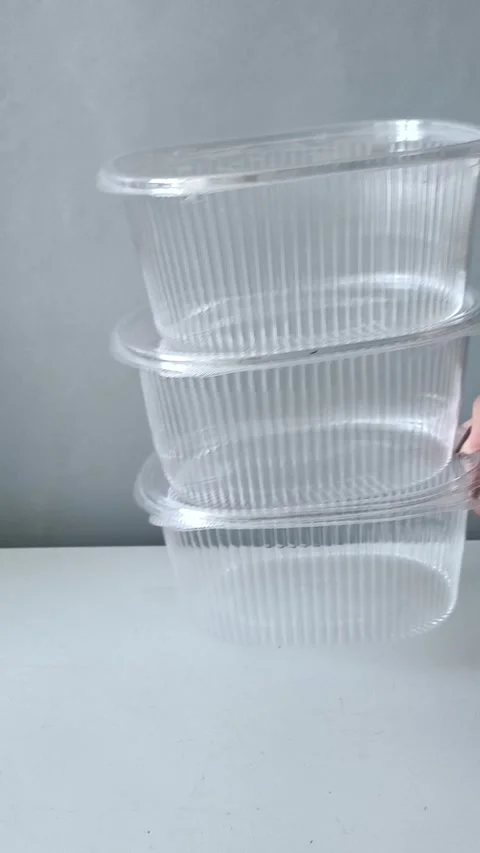 A womans hand puts disposable transparent containers on the table. Containers 库存影片 330156808