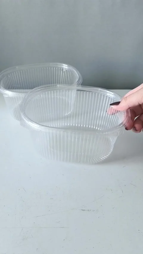 A womans hand puts disposable transparent containers on the table. Containers 库存影片 330156809