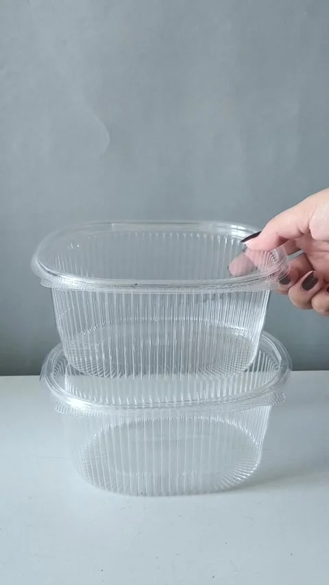 A womans hand puts disposable transparent containers on the table. Containers Stock Footage 330156900