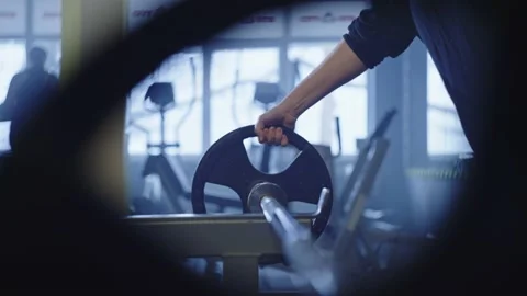 A woman's hand puts a load on the barbell in the gym. Stock Footage 234919693