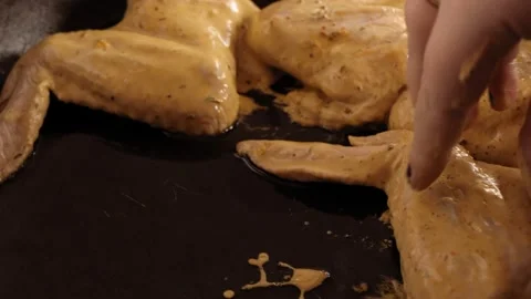 A woman's hand puts marinated chicken wings in a frying pan with oil Vidéo 172594479
