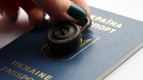 A woman's hand puts a padlock on a Ukrainian passport Stock Footage 264995615