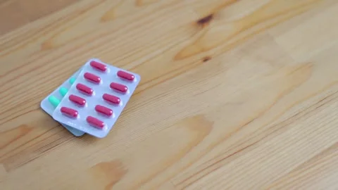 A woman's hand puts pills on the table. Taking vitamins. The woman refuses to Stock-Footage 262422387