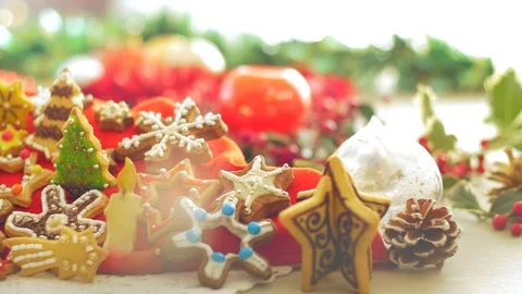 A woman's hand puts a shortbread sugar cookie on a Christmas decorated table. Stock Footage 70128506