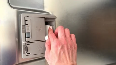 A woman's hand puts a tablet in the dishwasher before washing dishes. close-up Stock Footage 239923951