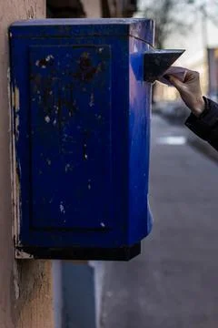A woman's hand puts a thin package in the mailbox Stock Photos
