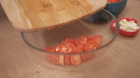 A woman's hand puts tomatoes on a plate. Preparing the sauce. Italian cooking Stock Footage 262432334