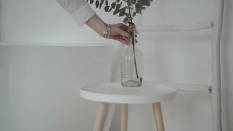 Woman's hand puts a vase on the table Stock Footage 168740516
