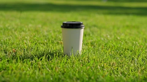 Woman's hand puts white paper disposable glass of coffee tea with black plastic Stock Footage 201382026