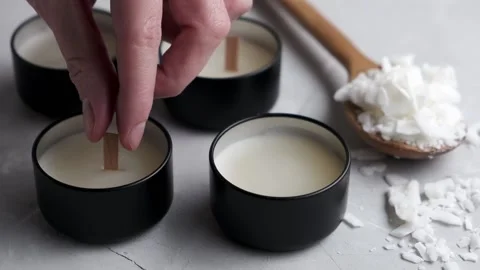 Woman's hand puts a wick in a soy wax candle Stock Footage 230111138